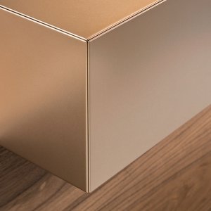 Nussbaumplatte und kupferfarbene Wangen am Empfangstresen Toki