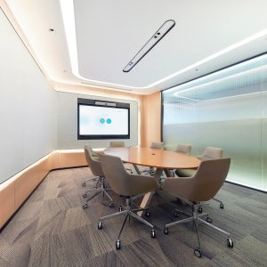 Aston Sessel am Kopfende des Konferenztisches