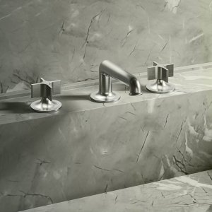 Design-Armaturen Flora als Wandausführung in Mokka PVD vor hellem Naturstein