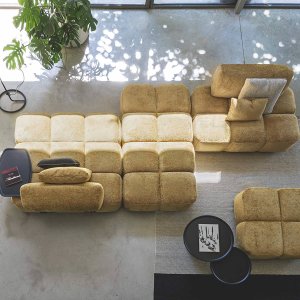 Pouf Qubik 147 × 100 cm vor einem Sofa der gleichen Serie